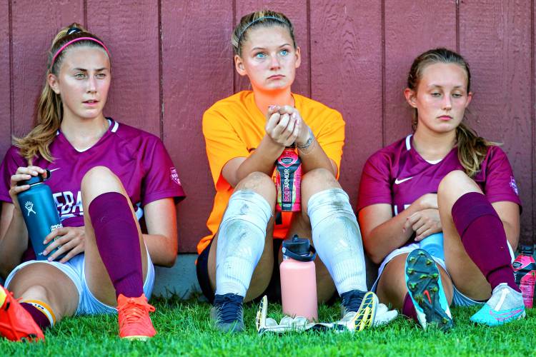 Lebanon High soccer players, from left, Sophie Longacre, Maezie Angles and Annie Hanna, listen to head coach Breck Taber speak during halftime of their Oct. 2, 2023, game against NHIAA Division II foe Merrimack Valley. Merrimack Valley won, 1-0.will the copy desk know that my Newport High football photos (they won) should be played over the Patriots for Monday’s paper?