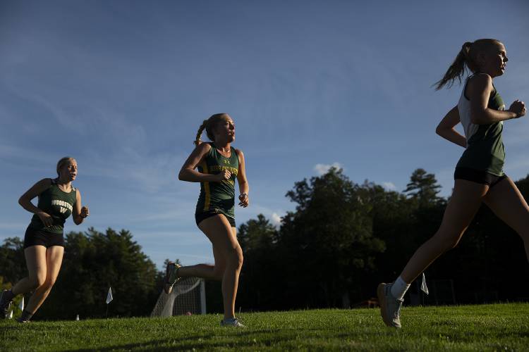 Woodstock senior Logan Knox, right, runs ahead of Burr and Burton sophomore Madelyn Harris and Woodstock junior Myra McNaughton during a cross country meet at Thetford Academy in Thetford, Vt., on Tuesday, Sept. 12, 2023. (Valley News / Report For America - Alex Driehaus) Copyright Valley News. May not be reprinted or used online without permission. Send requests to permission@vnews.com.