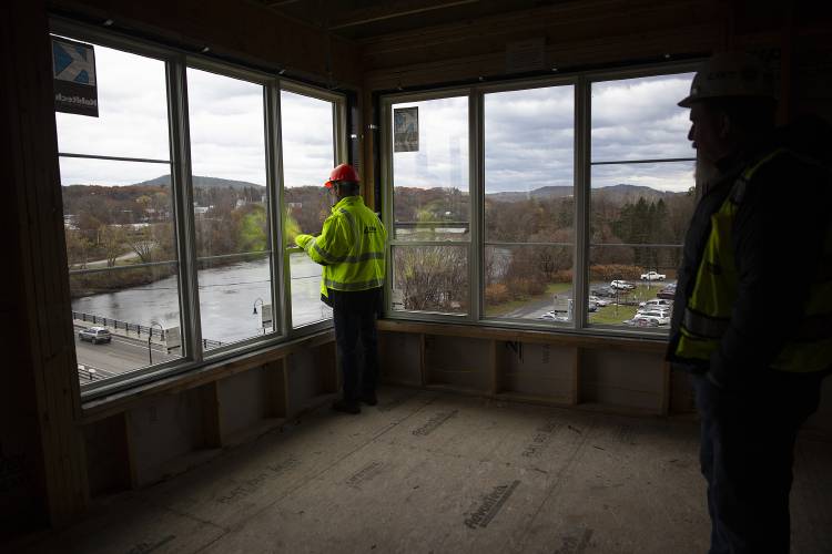 Twin Pines Housing Executive Director Andrew Winter, left, and DEW Construction Superintendent John Krezinski look out the window of an apartment in the Riverwalk Apartments development in White River Junction, Vt., on Friday, Nov. 10, 2023. The affordable housing development will have 42 units, including studios and one-, two- and three-bedroom apartments. (Valley News / Report For America - Alex Driehaus) Copyright Valley News. May not be reprinted or used online without permission. Send requests to permission@vnews.com.