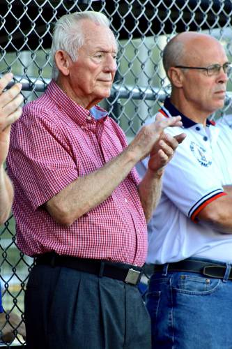 Chuck Hunnewell, left, a former high school and American Legion baseball coach in the Upper Valley, claps at the start of a Legion exhibition baseball game between White River Junction Post 84 and Lebanon Post 22 on June 25, 2017, at the Maxfield Sports Complex in White River Junction, Vt. At right is New Hampshire American Legion baseball director Rick Harvey.  (Valley News - Tris Wykes) Copyright Valley News. May not be reprinted or used online without permission.