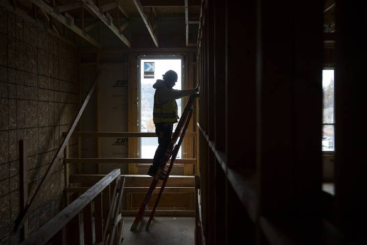 Jon Wheeler, an electrician with Norway & Sons, stands on a lean-safe ladder while mounting electrical equipment at Riverwalk Apartments in White River Junction, Vt., on Friday, Nov. 10, 2023. Construction on the development is expected to be completed in early April 2024. (Valley News / Report For America - Alex Driehaus) Copyright Valley News. May not be reprinted or used online without permission. Send requests to permission@vnews.com.