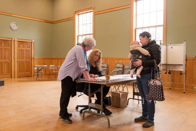 Barnard Town Clerk Diane Rainey, left, and Justice of the Peace Ellen Miles, middle, register Nicole McLeay, right, to vote at the Barnard, Vt., Town Hall, on Tuesday, March 5, 2024. McLeay said she registered when she moved to town in 2022, but was pregnant with her child Hadley and did not vote last year. (Valley News - James M. Patterson) Copyright Valley News. May not be reprinted or used online without permission. Send requests to permission@vnews.com.