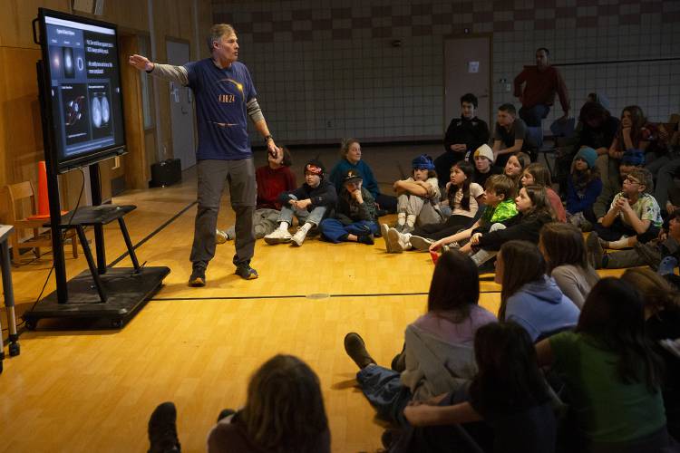 Rob Hanson, left, co-director of Horizons Observatory, gives a presentation on the upcoming solar eclipse at the Prosper Valley School in South Pomfret, Vt., on Wednesday, April 3, 2024. Hanson, who taught sixth grade at the school for 31 years, talked about the cosmic forces that create an eclipse and fielded questions from students. (Valley News / Report For America - Alex Driehaus) Copyright Valley News. May not be reprinted or used online without permission. Send requests to permission@vnews.com.