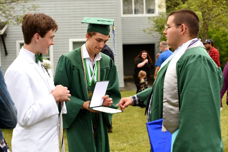 Rivendell Academy graduate and valedictorian Tovahn Vitols tries to close classmate Colin Gagner's pinkie in his diploma after their commencement ceremony on Saturday, June 10, 2023 in Orford, N.H. On the left is Class Marshal Eli Mansur. (Valley News - Jennifer Hauck) Copyright Valley News. May not be reprinted or used online without permission. Send requests to permission@vnews.com.