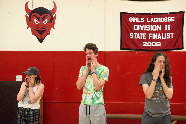 Chelsea Funnery participants, from left, Kiki Kenyon, 17, of South Royalton, Silas Adkins-Hooke, 17, of Alexandria, Va., and Jesse Waters-Malone, 16, of Boston, massage their jaws and do vocal warmups before a rehearsal of “Much Ado About Nothing” at the Chelsea, Vt., school on Tuesday, July 18, 2023. (Valley News - James M. Patterson) Copyright Valley News. May not be reprinted or used online without permission. Send requests to permission@vnews.com.