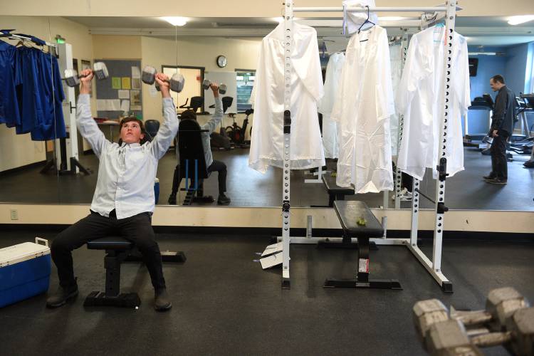 Before the start of the Thetford Academy commencement ceremony on Friday, June 9, 2023, in Thetford, Vt., graduate Nolan Pepe lifts weights before picking up his gown in the weight room at the school. Fellow graduates Thomas Berecz and Jacob Gilman were lifting with him. (Valley News - Jennifer Hauck) Copyright Valley News. May not be reprinted or used online without permission. Send requests to permission@vnews.com.