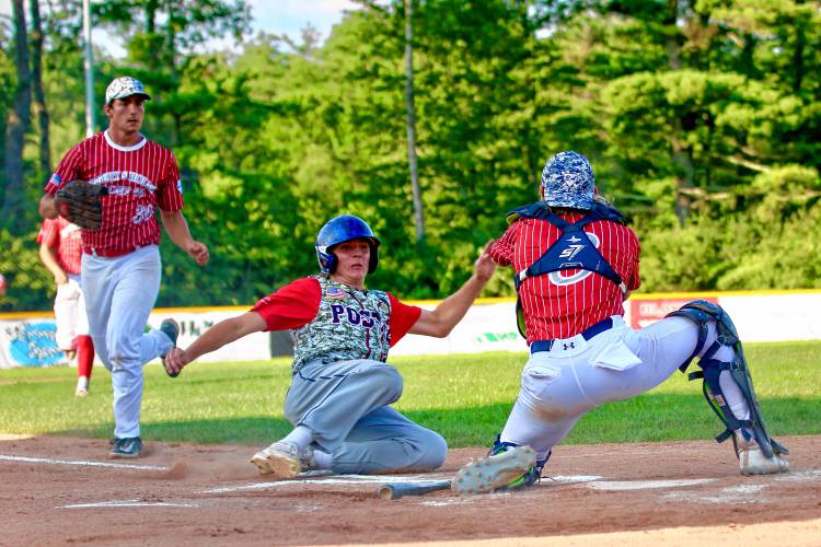 Lebanon Post 22 runner Wyatt Daigle slides before being tagged out by White River Junction Post 84 catcher Ethan Belvin during the American Legion senior baseball teams' July 19, 2023, exhibition game at the Maxfield Athletic Complex in White River Junction, Vt. Post 22 won, 10-9. (Valley News - Tris Wykes) Copyright Valley News. May not be reprinted or used online without permission. Send requests to permission@vnews.com.