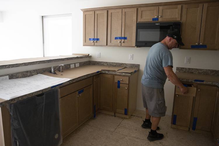 Jack Franks, President and CEO of Avanru Development Group, looks at the cabinetry in a newly-installed modular apartment on Spring Street in Newport, N.H., on Thursday, June 15, 2023. The apartments arrive from the manufacturing facility mostly complete and need finishing touches like flooring and additional appliances. Franks said he expects the building to be complete by October. (Valley News / Report For America - Alex Driehaus) Copyright Valley News. May not be reprinted or used online without permission. Send requests to permission@vnews.com.