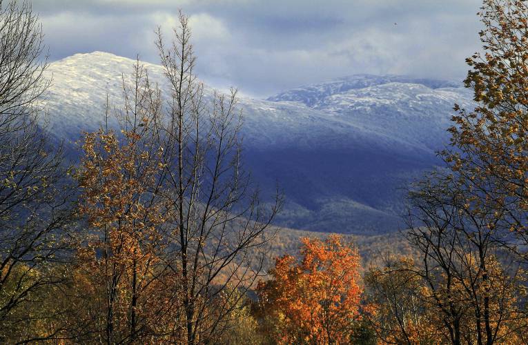 FILE - In this Oct. 11, 2012 file photo, the snow-covered peak of Mount Washington soars above fall foliage, as viewed from Jefferson, N.H. A growing list of environmental and recreational groups are coming out against plans to build an upscale hotel a mile from the mountain's summit. They argue the hotel will hurt the viewing experience and damage the fragile Alpine environment. (AP Photo/Jim Cole, File)