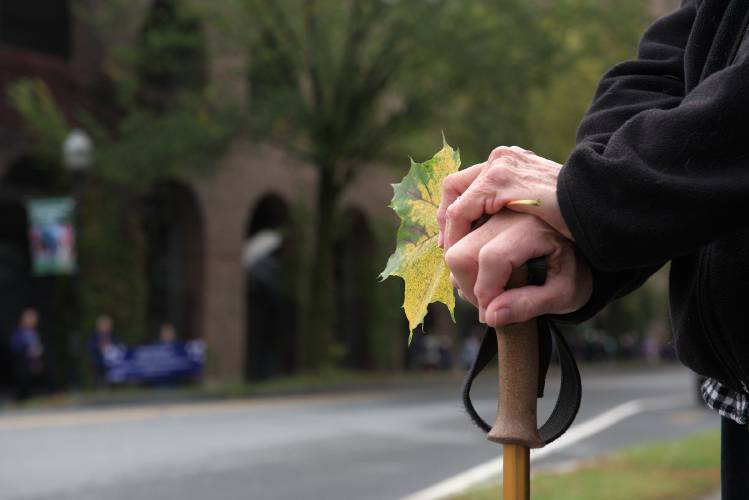 Sue, 84, of Claremont, who declined to give her last name, holds a fallen leaf as a sign of hope while waiting for her daughters to return from the Walk to End Alzheimer's in Hanover, N.H., on Saturday, Sept. 30, 2023. Sue was a caregiver for her husband who who had dementia and died recently. 