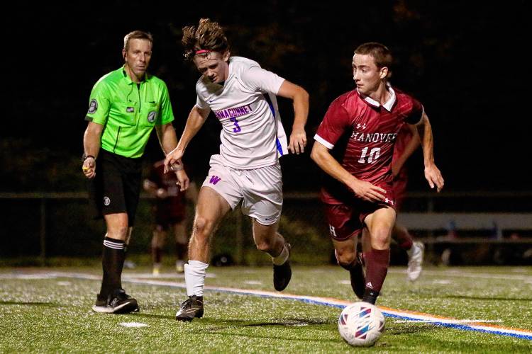 Hanover High's Carter Guerin (10) looks for options upfield while under pressure from Winnacunnet's Zane Lepere (3) during the NHIAA Division I teams' Oct. 27, 2023, game on Merriman-Branch Field in Hanover, N.H. Hanover won the quarterfinal playoff game, 5-1. (Valley News - Tris Wykes) Copyright Valley News. May not be reprinted or used online without permission. Send requests to permission@vnews.com.
