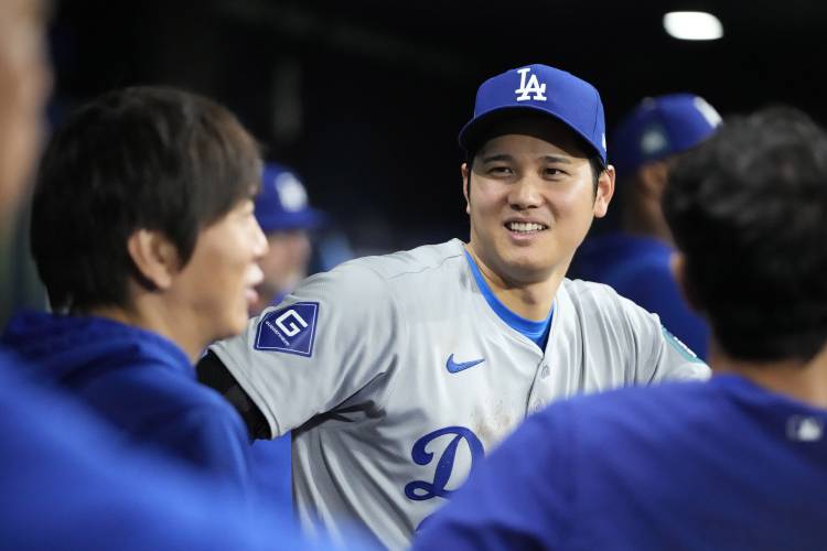 Los Angeles Dodgers designated hitter Shohei Ohtani, right, talks with interpreter Ippei Mizuhara during the ninth inning of an opening day baseball game against the San Diego Padres at the Gocheok Sky Dome in Seoul, South Korea Wednesday, March 20, 2024, in Seoul, South Korea. (AP Photo/Lee Jin-man)