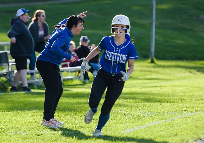 Eiea Morgan, of Thetford, rounds third and heads toward home as her mother, Head Coach Michelle Morgan, left, waves the next runner on during their 19-18 win over Spaulding in Thetford, Vt., on Tuesday, May 9, 2023. (Valley News - James M. Patterson) Copyright Valley News. May not be reprinted or used online without permission. Send requests to permission@vnews.com.