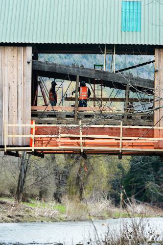 A crew from Wright Construction Company works Monday, April 25, 2022, to replace beams on the Lincoln Covered Bridge in West Woodstock, Vt. The bridge was damaged in September, 2021, when a truck towing heavy equipment that exceeded the posted height limit of 10 feet struck over head beams. In a similar incident in 2019, a truck towing a backhoe through the bridge caused roughly $1 million of damage. (Valley News - James M. Patterson) Copyright Valley News. May not be reprinted or used online without permission. Send requests to permission@vnews.com.