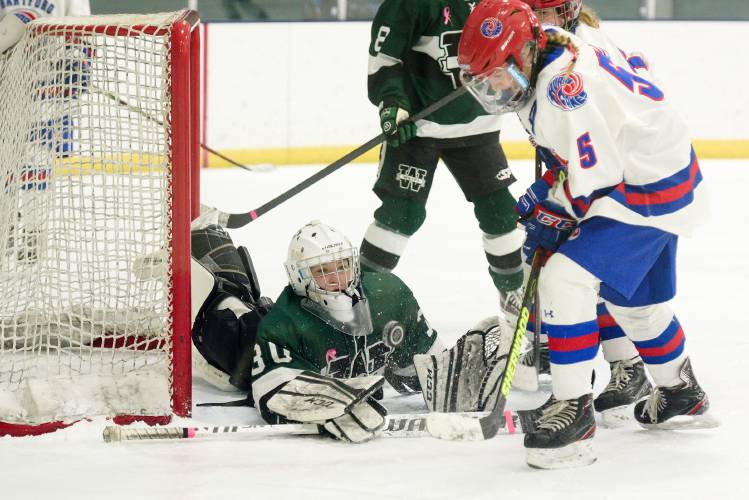 Woodstock goalie Meridian Bremel, left, deflects a series of shots from Hartford's Emma Bazin, 5, and Flynn Moreno, obscured, at Barwood Arena in White River Junction, Vt., on Wednesday, Jan. 18, 2024. Woodstock won 3-2. (Valley News - James M. Patterson) Copyright Valley News. May not be reprinted or used online without permission. Send requests to permission@vnews.com.