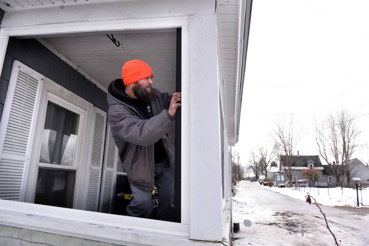 Nathan Roberts, Sr., of Claremont, N.H., works on a job next to his house on Friday, Feb. 2, 2024. Roberts, who owns a roofing and construction business, has organized a neighborhood watch group near his home. The group patrols twice a night, some with handguns (but Roberts does not carry a gun). Roberts has had his work truck broken into twice. Recently a teenager in the neighborhood was shot by a man who was allegedly breaking into cars.  (Valley News - Jennifer Hauck) Copyright Valley News. May not be reprinted or used online without permission. Send requests to permission@vnews.com.