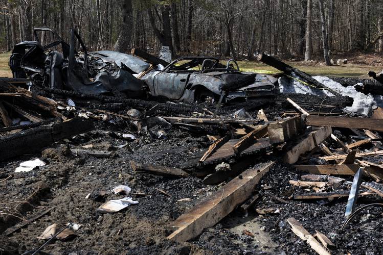 The remains of a sportscar and a truck sit in the pile of debris on Monday, April 3, 2023, from a fire early Sunday morning that destroyed a more than 200-year-old barn on the East Plainfield, N.H. (Valley News - James M. Patterson) Copyright Valley News. May not be reprinted or used online without permission. Send requests to permission@vnews.com.