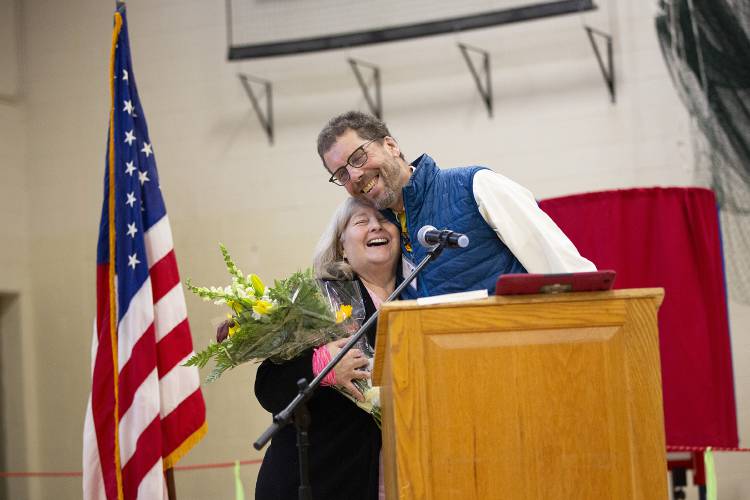 Outgoing Town Clerk Patty Jenks, left, receives a hug from Town Moderator Kevin Peterson while being honored for her 40 years of service in the Town Clerk’s Office during Town Meeting at the Lyme School in Lyme, N.H., on Tuesday, March 12, 2024. (Valley News / Report For America - Alex Driehaus) Copyright Valley News. May not be reprinted or used online without permission. Send requests to permission@vnews.com.