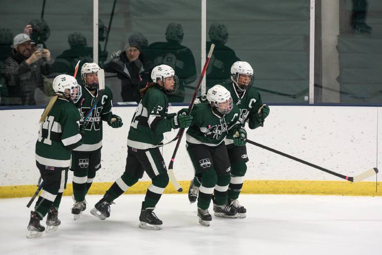 Gracelyn Laperle, second from right, turns back to the ice after celebrating her 100th point with her dad Gary Laperle, back left, and Woodstock teammates, from left, Fiona Piconi, Margaret Mello, Lila Beckwith, and Hannah Gubbins, right, during their game with Hartford in White River Junction, Vt., on Wednesday, Jan. 18, 2024. Laperle went on to contribute a second goal to the Wasps 3-2 overtime win over the Hurricanes. (Valley News - James M. Patterson) Copyright Valley News. May not be reprinted or used online without permission. Send requests to permission@vnews.com.