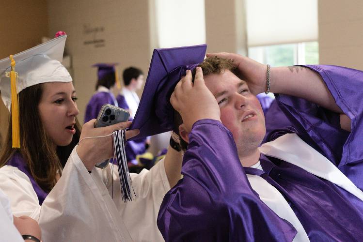 Isaiah Drexler, right, tries to keep his mortar board on his head as Josie Nestle, left, pulls it close to read as graduating seniors gather before commencement at Mascoma High School in West Canaan, N.H., on Friday, June 16, 2023. (Valley News - James M. Patterson) Copyright Valley News. May not be reprinted or used online without permission. Send requests to permission@vnews.com.