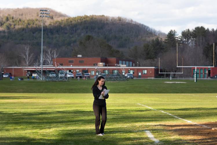Woodstock varsity softball head coach Angela Allard fills out her score sheet as she coaches third base during a game against Mill River Union High School at Woodstock Union High School in Woodstock, Vt., on Friday, April 22, 2022. Woodstock won, 19-7. (Valley News / Report For America - Alex Driehaus) Copyright Valley News. May not be reprinted or used online without permission. Send requests to permission@vnews.com.