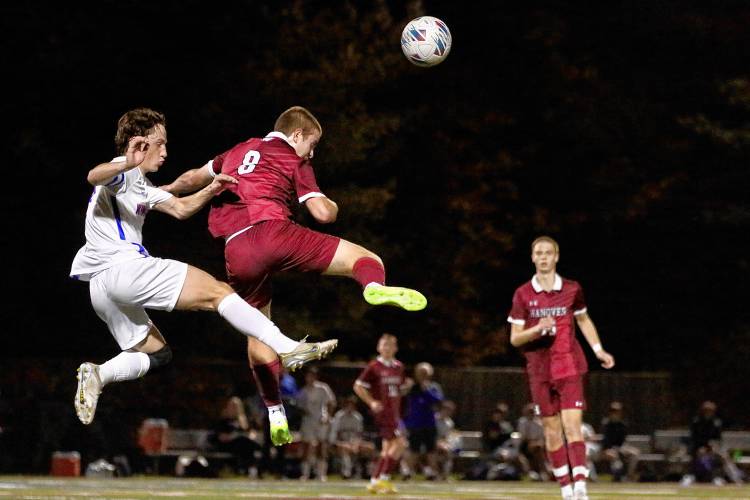 Hanover High's Andrew McGuire (8) and Winnacunnet's Noah Souther fly through the air during the NHIAA Division I teams' Oct. 27, 2023, playoff quarterfinal game on Merriman-Branch Field in Hanover, N.H. Hanover won, 5-1. (Valley News - Tris Wykes) Copyright Valley News. May not be reprinted or used online without permission. Send requests to permission@vnews.com.