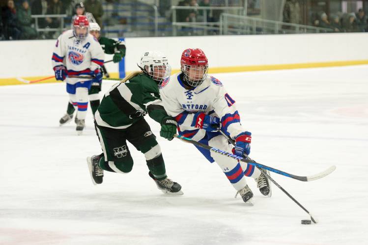 Braelyn Park, of Hartford, right, maneuvers around Fiona Piconi, of Woodstock, left, to shoot on goal at Barwood Arena in White River Junction, Vt., on Wednesday, Jan. 18, 2024. Woodstock won 3-2. (Valley News - James M. Patterson) Copyright Valley News. May not be reprinted or used online without permission. Send requests to permission@vnews.com.