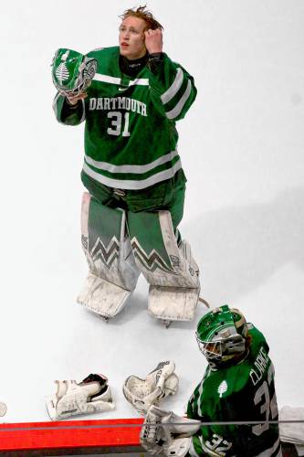 Dartmouth College goaltender Cooper Black looks skyward as he prepares to put his helmet back on during a media timeout of the ECAC playoff semifinals against Cornell on March 22, 2024. Backup Roan Clarke is at bottom. Cornell won, 6-3, at Herb Brooks Arena in Lake Placid, N.Y. (Valley News - Tris Wykes) Copyright Valley News. May not be reprinted or used online without permission. 
