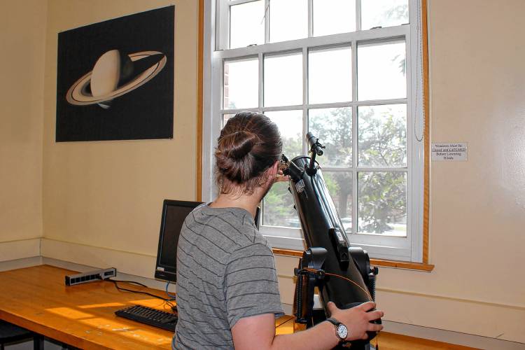 Jack Duranceau looks through a telescope inside the astronomy lab in Wilder Hall at Dartmouth College on Monday, Aug. 21, 2023. (VtDigger - Max Scheinblum)