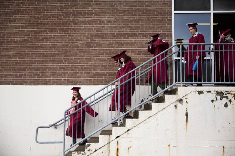 Graduates make final adjustments to their caps and gowns as they walk toward the gym before their graduation ceremony at Hanover High School in Hanover, N.H., on Friday, June 9, 2023. (Valley News / Report For America - Alex Driehaus) Copyright Valley News. May not be reprinted or used online without permission. Send requests to permission@vnews.com.