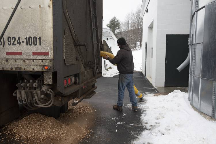 Lucas Perry, a truck driver for Froling Energy, returns a tube to his truck after using it to vacuum wood chips into a 20-foot silo next to the Sherburne Gym in Sunapee, N.H., on Thursday, Feb. 1, 2024. Froling’s trucks are custom fitted and can send out ten tons of wood chips in about an hour. (Valley News / Report For America - Alex Driehaus) Copyright Valley News. May not be reprinted or used online without permission. Send requests to permission@vnews.com.
