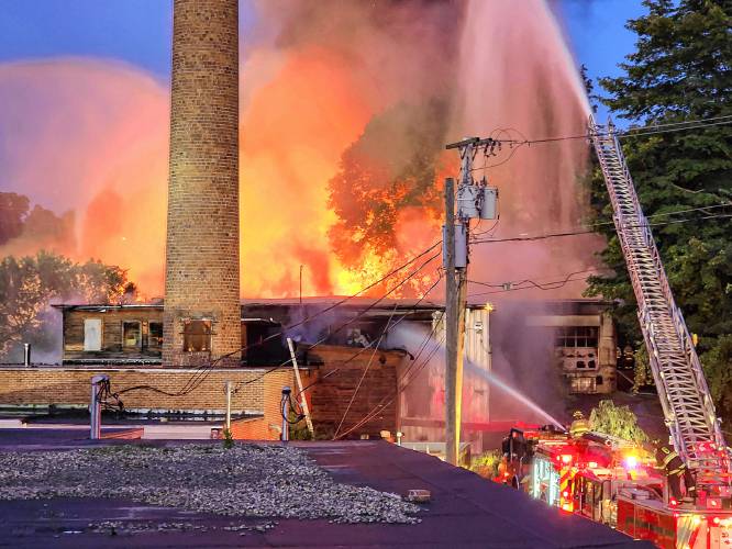 Firefighters battle the warehouse fire blaze off Sullivan Street in Claremont, N.H., in a photograph taken by Kurt Zentmaier, the building's property manager and former owner of the property, on Saturday, Aug. 5, 2023. (Courtesy Kurt Zentmaier)