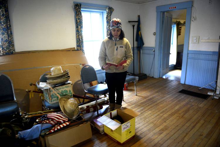 Olive Isaacs, of Norwich, Vt., pages through a song book at the Upper Valley Community Grange #581 on Thursday, Nov. 3, 2023, in Norwich. Isaacs, a board member of the Norwich Community Collaborative recently purchased the building for $1 and they are deciding how to renovate the space.  (Valley News - Jennifer Hauck) Copyright Valley News. May not be reprinted or used online without permission. Send requests to permission@vnews.com.