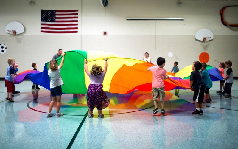 First-graders at Allenstown Elementary School work with a giant parachute during gym class on the first day of class on Tuesday, August 28, 2018. Principal Ginelle Czerula said that students will be brought inside for recess today because of the heat.


