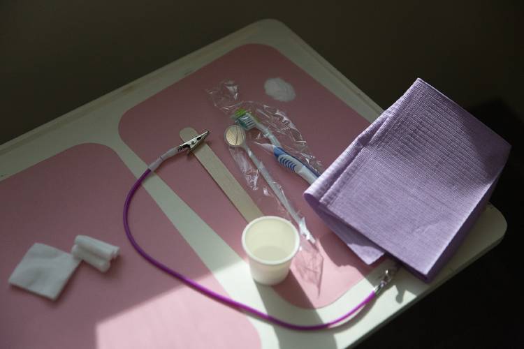 A toothbrush, mirror and cotton swabs sit on a tray ready for the next patient during a free dental clinic at the Vermont Agency of Human Services Hartford District Office Building in White River Junction, Vt., on Friday, Feb. 9, 2024. Northeast Delta Dental donated $500 to the clinic to help purchase needed supplies, Dr. John Echternach said. (Valley News / Report For America - Alex Driehaus) Copyright Valley News. May not be reprinted or used online without permission. Send requests to permission@vnews.com.