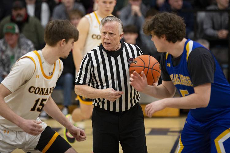 Referee Peter DePalo talks to Conant forward Jordan Nagle (15) and Kearsarge forward Parker Goin (5) before the tipoff of a NHIAA Division III boys basketball semifinal game at Bow High School in Bow, N.H., on Tuesday, Feb. 20, 2024. (Valley News / Report For America - Alex Driehaus) Copyright Valley News. May not be reprinted or used online without permission. Send requests to permission@vnews.com.