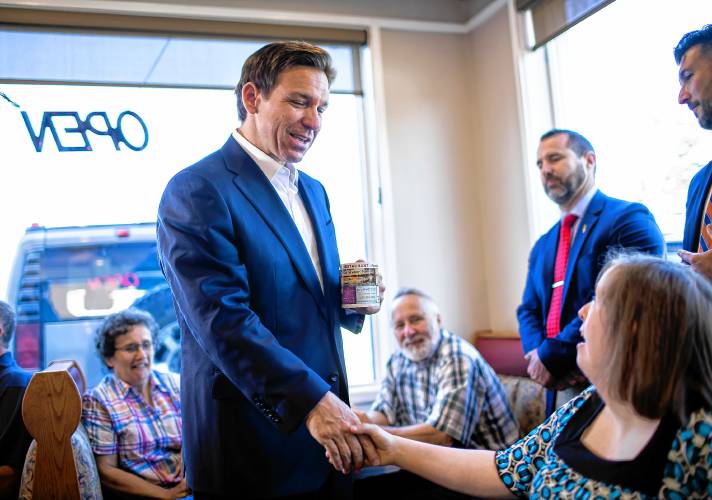 Coffee in hand, Florida Gov. Ron DeSantis says hello to Hayley Smiglowski at the Windmill Restaurant on Tuesday morning, August 1, 2023.