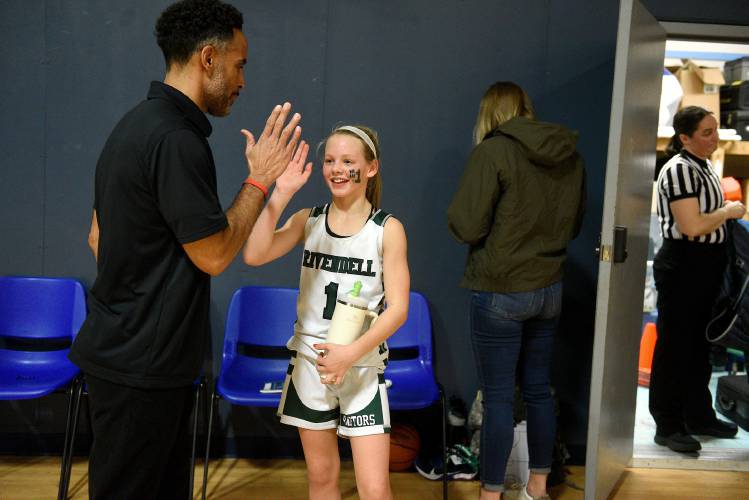 Rivendell Academy middle school basketball coach Ross Jensen high-fives player Grace Bourn after the team's win against Oxbow on Thursday, Jan. 11, 2024, in Orford, N.H. Jensen is also Rivendell's varsity basketball coach. (Valley News - Jennifer Hauck) Copyright Valley News. May not be reprinted or used online without permission. Send requests to permission@vnews.com.