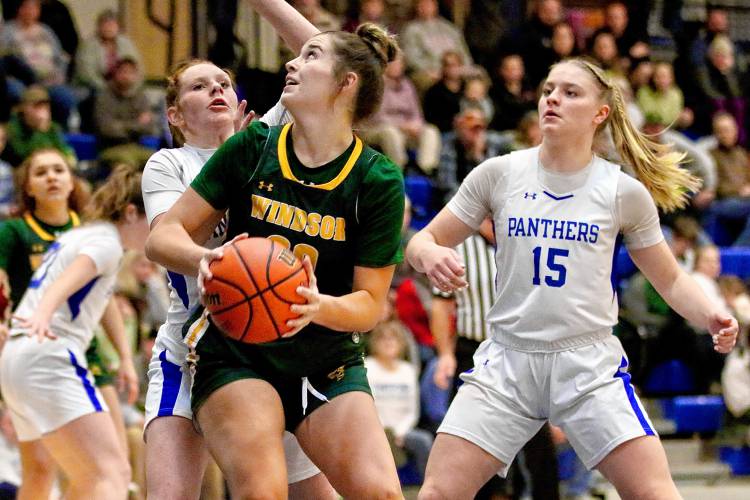 Windsor High's Sydney Perry, center, looks to score against Thetford Academy defenders Rebecca Osgood, left, and Addison Cadwell, right. Perry led all scorers with 15 points during her team's 41-31 victory on Dec. 21, 2023, in Thetford, Vt.