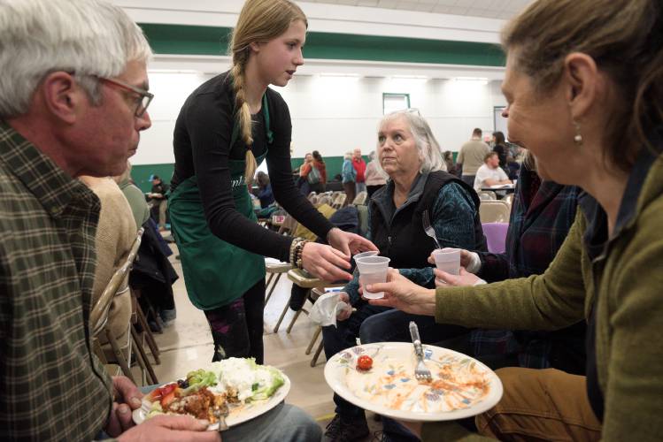 Lillian Aiken, 14, serves water and takes orders for pie from Selectboard member Gary Mullen, left, Lister Deb Mullen, second from right, Heather Mullen, obscured, and Lori Berger, front right, during a lunch break from Town Meeting in Tunbridge, Vt., on Tuesday, March 5, 2024. (Valley News - James M. Patterson) Copyright Valley News. May not be reprinted or used online without permission. Send requests to permission@vnews.com.