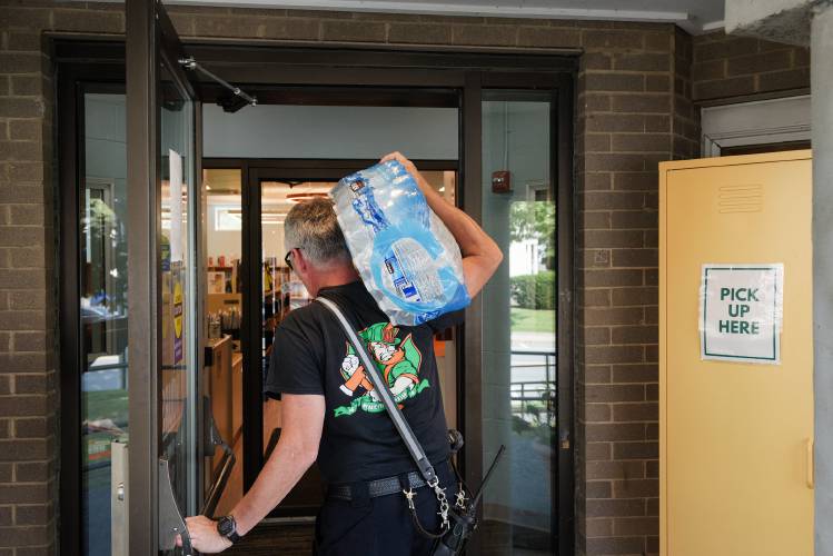 Fire Inspector Charlie Barker refills a cooler with bottled water at the Lebanon Library, one of four cooling stations in the city, including Kilton Library, the Upper Valley Senior Center and the Lebanon Airport, in Lebanon, N.H., on Wednesday, Sept. 6, 2023. (Valley News - James M. Patterson) Copyright Valley News. May not be reprinted or used online without permission. Send requests to permission@vnews.com.