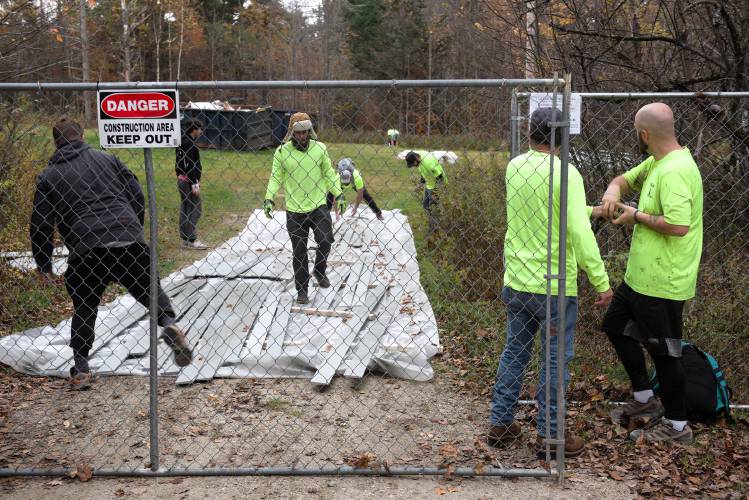 Workers close up their staging area and landing zone at the edge of Cardigan Mountain State Forest in Orange, N.H., after a helicopter delivered walls and other materials to the summit for the fire tower restoration on Thursday, Oct. 26, 2023. (Valley News - James M. Patterson) Copyright Valley News. May not be reprinted or used online without permission. Send requests to permission@vnews.com.