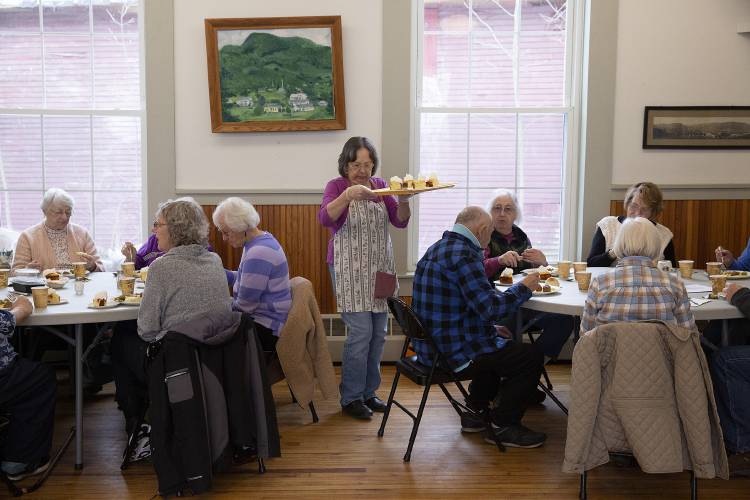 Volunteer Claire Brock, center, of Tunbridge, Vt., delivers dessert to lunch attendees at the Royalton Area Senior Citizens Center in Royalton, Vt., on Tuesday, Jan. 30, 2024. (Valley News / Report For America - Alex Driehaus) Copyright Valley News. May not be reprinted or used online without permission. Send requests to permission@vnews.com.