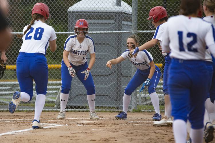 Hartford’s Logan Evans (28) runs toward home plate after hitting the ball over the fence as her teammates Madison Willey (17) and Paige Vielleux (1) cheer her on during a VPA Division II softball quarterfinal game against Rice Memorial High School at Maxfield Sports Complex in White River Junction, Vt., on Monday, June 5, 2023. Hartford won, 22-7. (Valley News / Report For America - Alex Driehaus) Copyright Valley News. May not be reprinted or used online without permission. Send requests to permission@vnews.com.