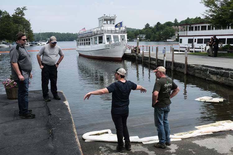 Officials from the New Hampshire Department of Environmental Services, from left, Jason Domke, Andrew Madison, and Cam Simmons, and Sunapee Fire Chief John Galloway, right, assess the state of a fuel spill in Sunapee Harbor on Monday, June 12, 2023. On Saturday afternoon, about 70 gallons fo fuel spilled from the Sunapee Lake Queen, at far right, and local emergency crews acted quickly to contain the spill in the harbor, protecting the Sugar River and the town's drinking water source farther out in the harbor. (Valley News - James M. Patterson) Copyright Valley News. May not be reprinted or used online without permission. Send requests to permission@vnews.com.