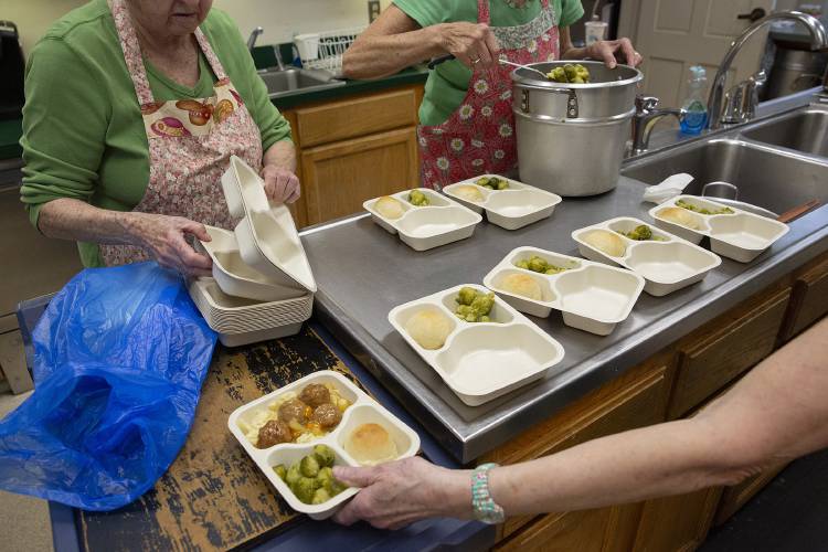 Clockwise from top left, Marge Turner, of East Bethel, Vt., Ilse Knowles, of East Bethel, and Mary Lamb, of Randolph, Vt., package lunch leftovers into meals for home delivery at the Royalton Area Senior Citizens Center in Royalton, Vt., on Tuesday, Jan. 30, 2024. Volunteers prepare over 100 meals for dine in, grab and go, and home delivery recipients. (Valley News / Report For America - Alex Driehaus) Copyright Valley News. May not be reprinted or used online without permission. Send requests to permission@vnews.com.