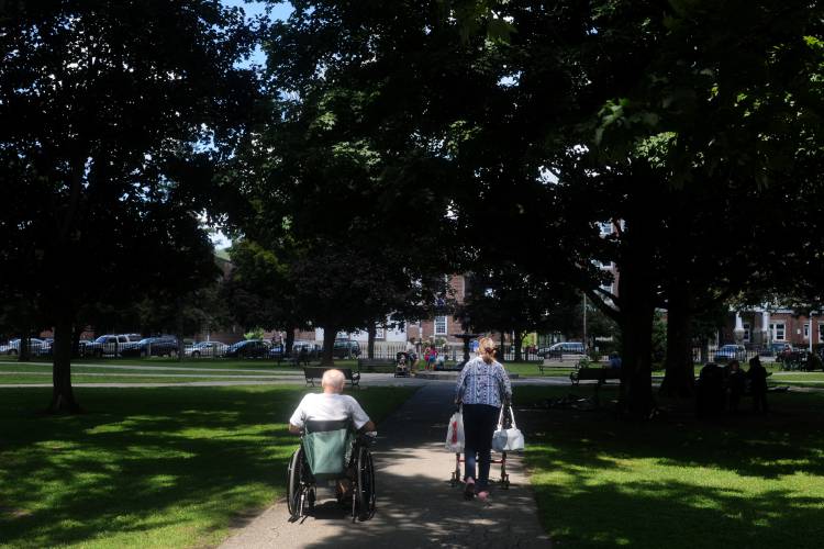 Bernard Rogers, left, and Jacqueline Digby walk through Colburn Park in Lebanon, N.H., on their way back to Rogers House after grocery shopping on August 2, 2013. 

Valley News - Sarah Priestap