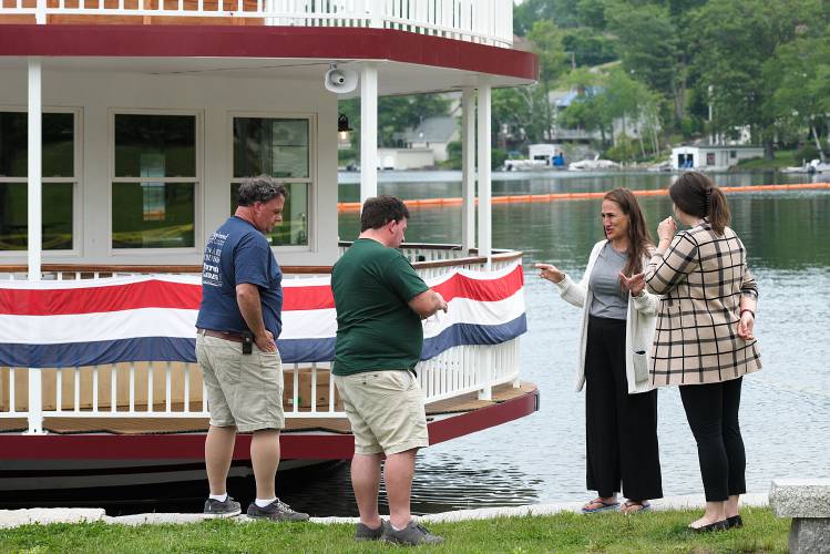 Sunapee Town Manager Shannon Martinez, second from right, and her executive assistant Allyson Traeger, right, talk on Monday, June 12, 2023, with brothers Peter, left, and Tim Fenton, owners of the Sunapee Lake Queen, a tour boat that was the site of a fuel spill in Sunapee, N.H., on Saturday. After much of the fuel was vacuumed off the surface of the water on Sunday, a floating orange boom was being drawn in to reduce the containment area on Monday. (Valley News - James M. Patterson) Copyright Valley News. May not be reprinted or used online without permission. Send requests to permission@vnews.com.