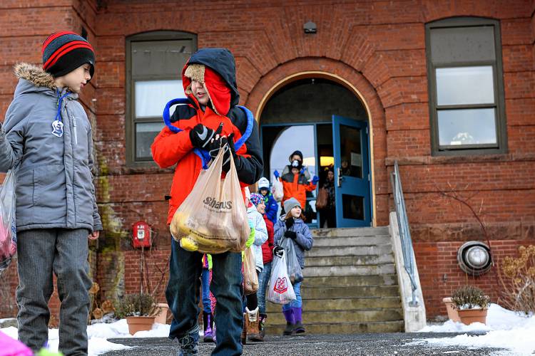 Richards Elementary School fourth-graders David Irwin, left, and Emrhys Medbery leave the school on Dec.9, 2016 with pounds of potatoes they were carrying to the Newport Food Pantry. The school collected over a thousand pounds of potatoes, a tradition at the school for 24 years.  (Valley News - Jennifer Hauck) Copyright Valley News. May not be reprinted or used online without permission. Send requests to permission@vnews.com.