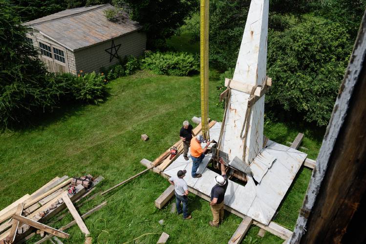 Clockwise from top left, Jan Lewandoski, Dan Larocque, of Classen’s Crane Service, Adam King, and Tony Mason, of Classen’s Crane Service, remove the rigging from the First Universalist Church spire in Barnard, Vt., on Wednesday, July 19, 2023 after setting it on a temporary platform where it will be repaired and reclad in metal roofing. When preparing the spire to be plucked from the building Lewandoski found severe rot in the timbers holding the structure up. “No plate was continuous,” he said. “Every one was patched in with two-bys.” (Valley News - James M. Patterson) Copyright Valley News. May not be reprinted or used online without permission. Send requests to permission@vnews.com.